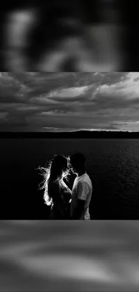 This stunning live wallpaper features a beautiful black and white photograph of a romantic couple standing in a serene lake