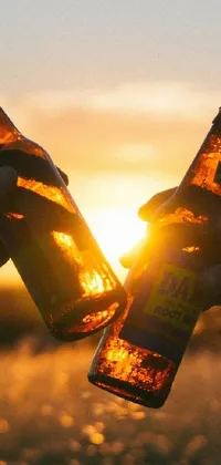 This stunning live phone wallpaper captures two individuals sharing beer while observing the sunset