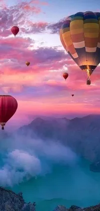 Enjoy the breathtaking view of hot air balloons flying over a mountain with this stunning live wallpaper on your phone