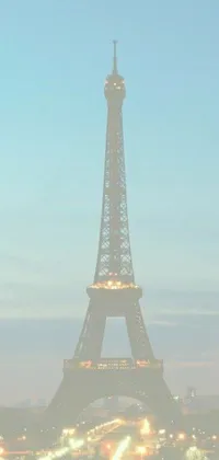 Enhance your phone's screen with the Eiffel Tower Live Wallpaper! This is an exquisite phone background featuring the emblematic Parisian monument at nighttime with a misty fog around the base