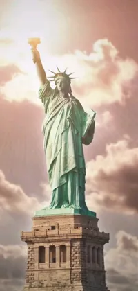 This live wallpaper features a stunning image of the iconic Statue of Liberty against a cloudy sky with warm golden hour lighting, perfect for phone screens