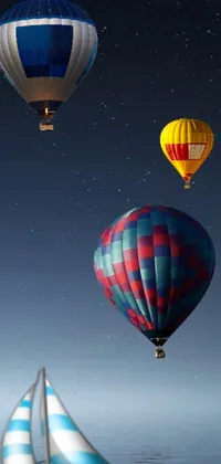 This phone live wallpaper features a captivating scene of hot air balloons soaring over a shimmering body of water under a clear, starry night sky