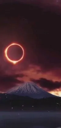 This live phone wallpaper showcases a stunning scene of a mountain with a blazing ring of fire in the background