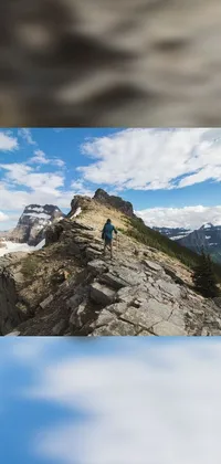This phone live wallpaper showcases stunning scenery with a man standing atop a rocky mountain, overlooking a breathtaking view of Banff National Park