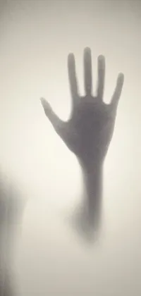 This phone live wallpaper features a surrealistic close-up of a ghostly hand behind frosted glass with a silhouette of SCP-173