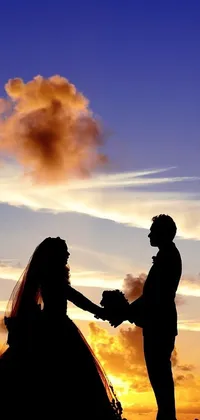 This phone live wallpaper is a beautiful silhouette of a bride and groom against a stunning sunset backdrop