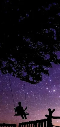 This live phone wallpaper features a beautiful silhouette of a person swinging at night under a cosmic purple sky, with a charming campfire burning in the background