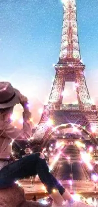This phone live wallpaper features a mystical cartoon-like woman sitting on a rock in front of the Eiffel Tower, with a luminous sparkling crystal design surrounding her