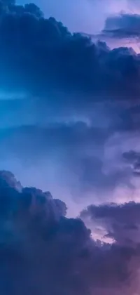 This phone live wallpaper features a stunning sky filled with purple and blue clouds that move slowly across the screen