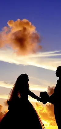 Add a touch of romance to your phone's background with this stunning live wallpaper featuring a silhouette of a bride and groom holding hands against a beautiful sunset and cloudy sky