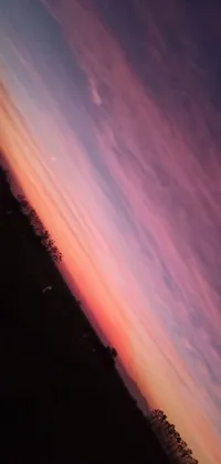 This lively smartphone wallpaper depicts a breathtaking sunset and adds a quirky touch with an airplane flying through the sky