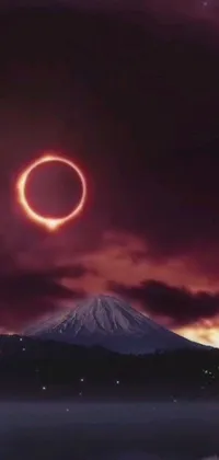 Experience the breathtaking sight of a ring of fire in the sky over a majestic mountain with this realistic photo live wallpaper