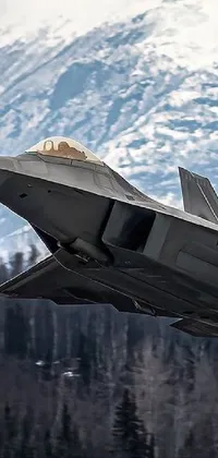 This <a href="/">dynamic phone wallpaper</a> features a fighter jet in flight against a majestic mountain backdrop