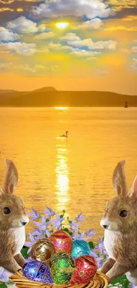 This Android phone wallpaper features two rabbits seated next to a basket of eggs, amid a digital rendering with a beach sunset backdrop and a close-up view