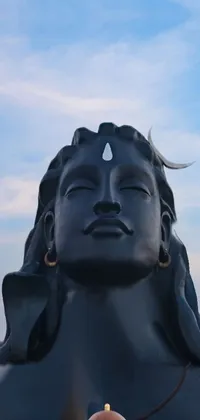 This stunning live wallpaper depicts a towering female statue in deep meditation, set against a striking black moon with horns, symbolizing the Hindu god Shiva