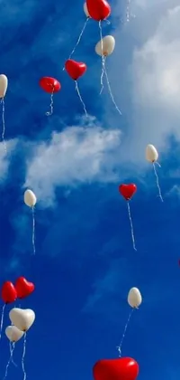 This live wallpaper for phones showcases red and white balloons floating freely in the sky