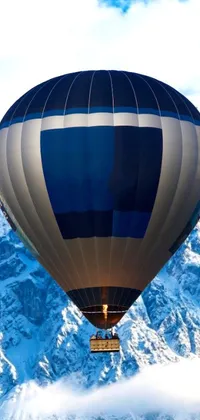 Immerse yourself in a stunning digital rendering of a hot air balloon floating over a snow-covered mountain