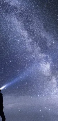 Transform your phone's background with this breathtaking live wallpaper featuring a portrait captured atop a majestic mountain with a sky full of shimmering stars
