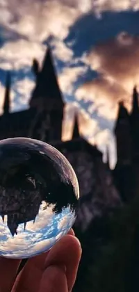 This live wallpaper is a stunning depiction of a crystal ball in front of a castle, with the picturesque Hogwarts in the background