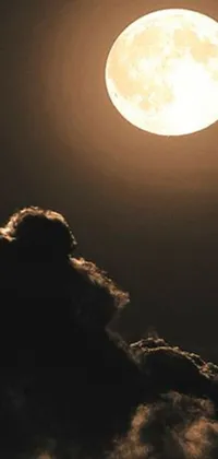 This live wallpaper depicts a black and white photograph of a full moon, radiating a serene yellowish light, against a backdrop of clouds