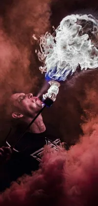This cool and striking live wallpaper features a man with smoke rising from his mouth, holding a torch