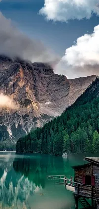 This phone live wallpaper features a beautiful and elegant scene of a cozy cabin situated in the middle of a crystal-clear lake, surrounded by majestic mountains in the background
