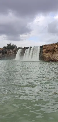 This phone live wallpaper showcases a breathtaking waterfall amidst serene surroundings