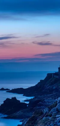 This breathtaking live phone wallpaper features a stunning castle atop a cliff next to the ocean