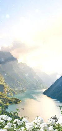 This stunning live wallpaper depicts a serene water body surrounded by majestic mountains and basked in warm summer light