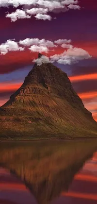 Enjoy the scenic beauty of a mountain mirrored in water at sunset with this stunning live wallpaper