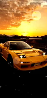 An exquisite live wallpaper for your phone featuring a dynamic yellow sports car parked in a scenic field against a breathtaking sunset