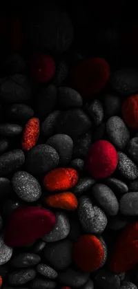 This live phone wallpaper features a minimalistic design of a pile of rocks covered in red sand