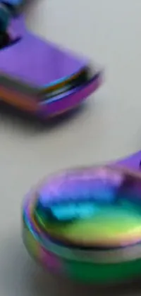 Get mesmerized with this holographic phone wallpaper featuring two iridescent titanium fidget spinners up close