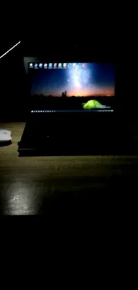 This phone live wallpaper showcases a sleek laptop computer resting on a wooden desk in a dimly lit room at 3 AM