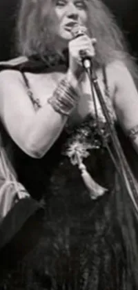 This phone live wallpaper showcases a monochrome photo of a singing woman in belly dancing attire with bangles, captured in the art nouveau style by a renowned artist