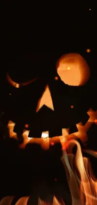 Get into the Halloween spirit with this spooky live wallpaper featuring a lit up jack-o-lantern in the dark