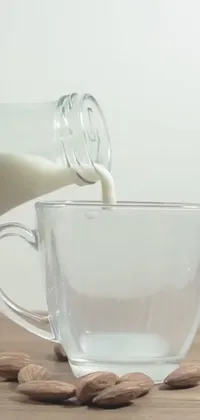 This realistic live wallpaper features a glass cup full of almonds and a bottle of milk beside it, with a Reddit logo in the background