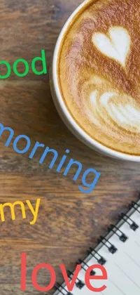 This Phone Live Wallpaper features a delightful image of a cup of coffee on a wooden table, accompanied by a charming font that spells out "good morning" and "happening"