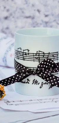 This coffee-themed live wallpaper features a close-up view of a cup with steam rising into floating musical notes against a white and black-spotted satin backdrop