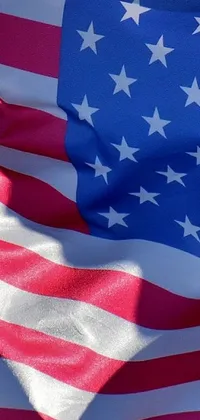 This live wallpaper features the American flag waving in the wind against a blue sky background