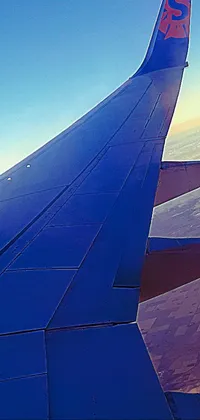 Fly high with this incredible live wallpaper featuring an airplane wing soaring through a bright blue sky