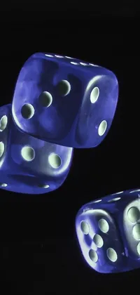This live phone wallpaper features blue dice on a table in a macro photograph