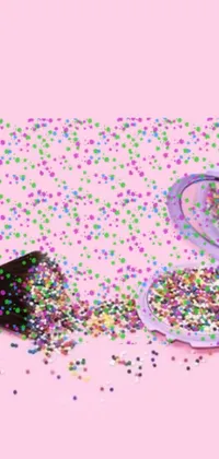 This live phone wallpaper features a colorful heap of confetti with sparkling and shimmering effects on a bright pink background
