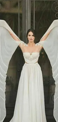 This stunning live phone wallpaper showcases a beautiful woman in a flowing white gown, with exquisite wings in the frame