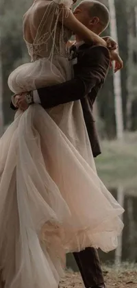 This phone live wallpaper captures a romantic moment of a couple in their wedding attire, embraced in a beautiful vera wang couture dress