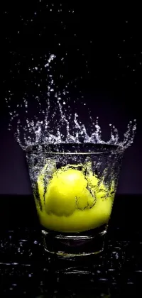 This live wallpaper for your phone features a beautiful digital art image of a lemon splashing into a glass of water