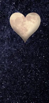 This phone live wallpaper features a heart shaped object set against a dark blue sky adorned with stars and a captivating space scene