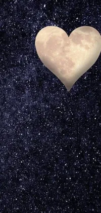 This phone live wallpaper, created by an artist, showcases a beautifully designed heart-shaped object floating under the luminous moon in the sky