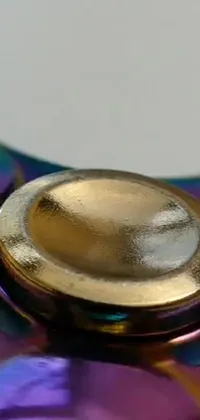Experience an awe-inspiring live wallpaper for your phone with a stunning macro photograph of a purple and gold fidget spinner