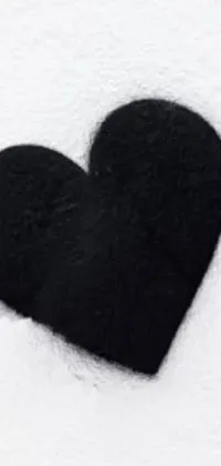 This phone live wallpaper features a stylish black heart design set against a snow-covered background